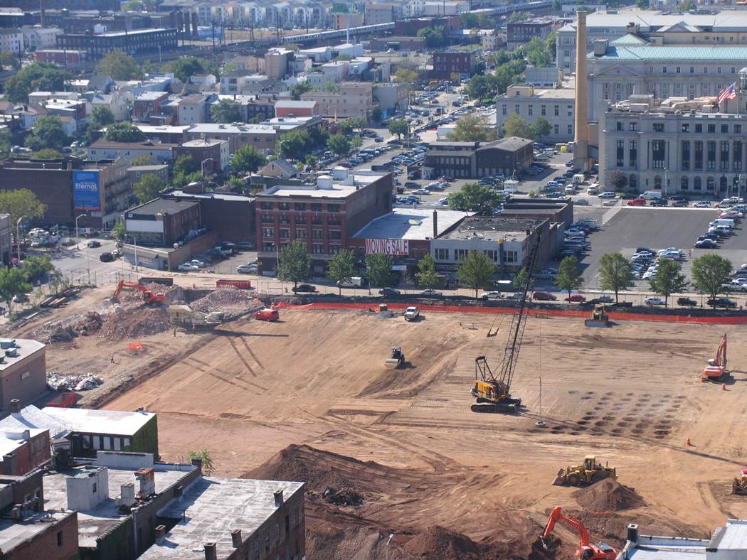urban-construction-site-dynamic-compaction-grid-densification Urban construction site with crane performing dynamic compaction and visible grid of soil impact points.